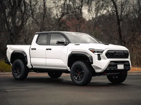 A white pickup truck parked on a paved lot